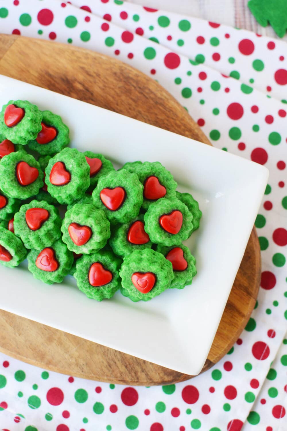 Green shortbread bites with heart candy on a tray.