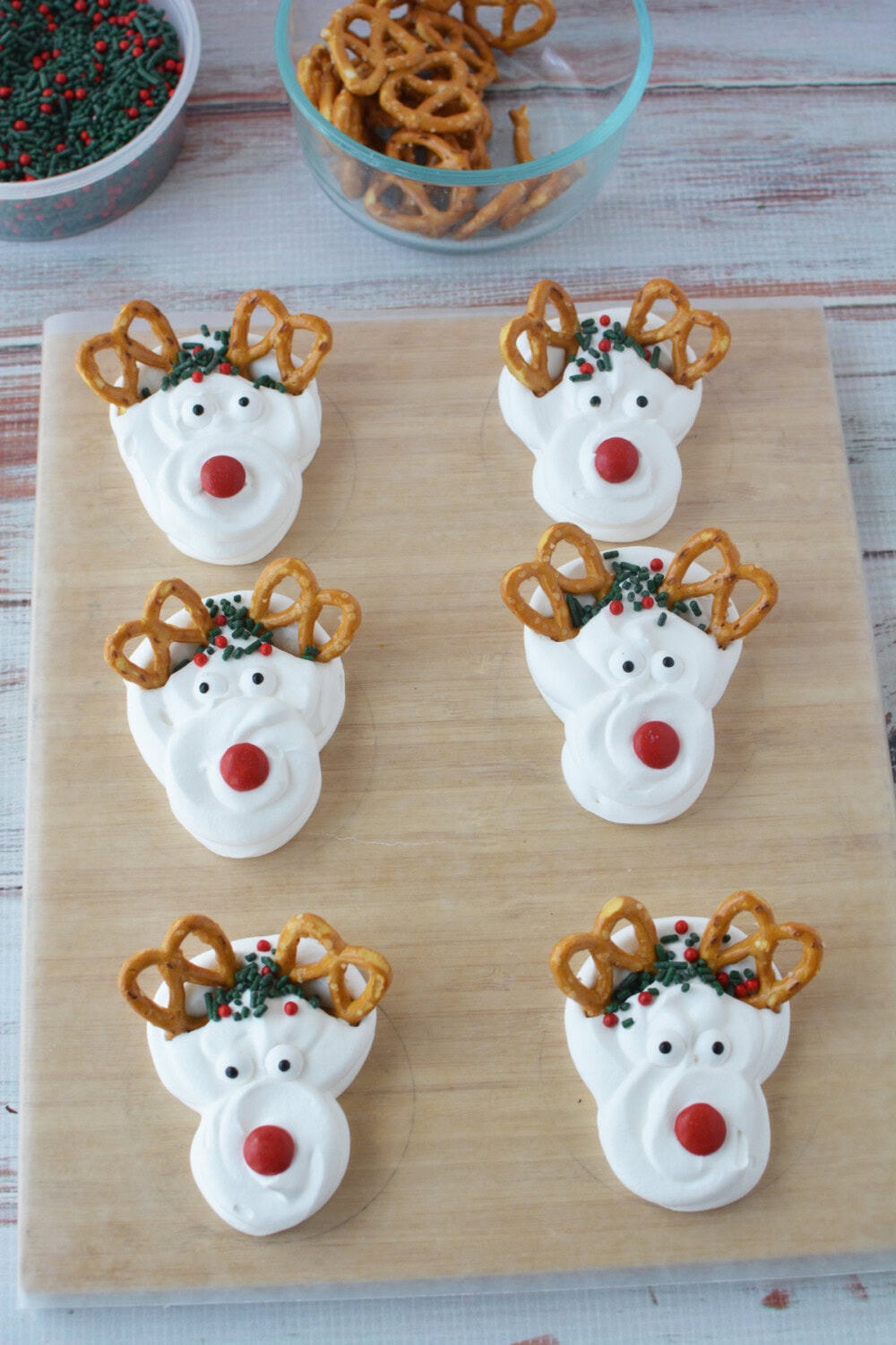 Six whipped cream reindeer toppers on parchment paper