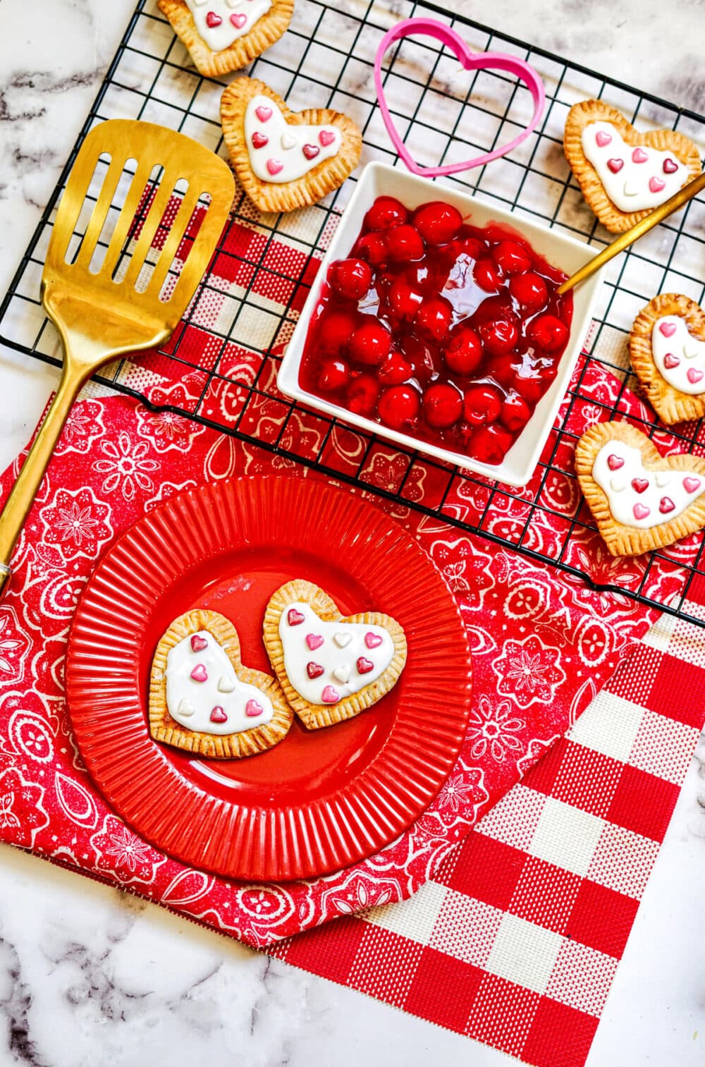 Heart Pop Tarts with Valentine's Day sprinkles on a red plate.