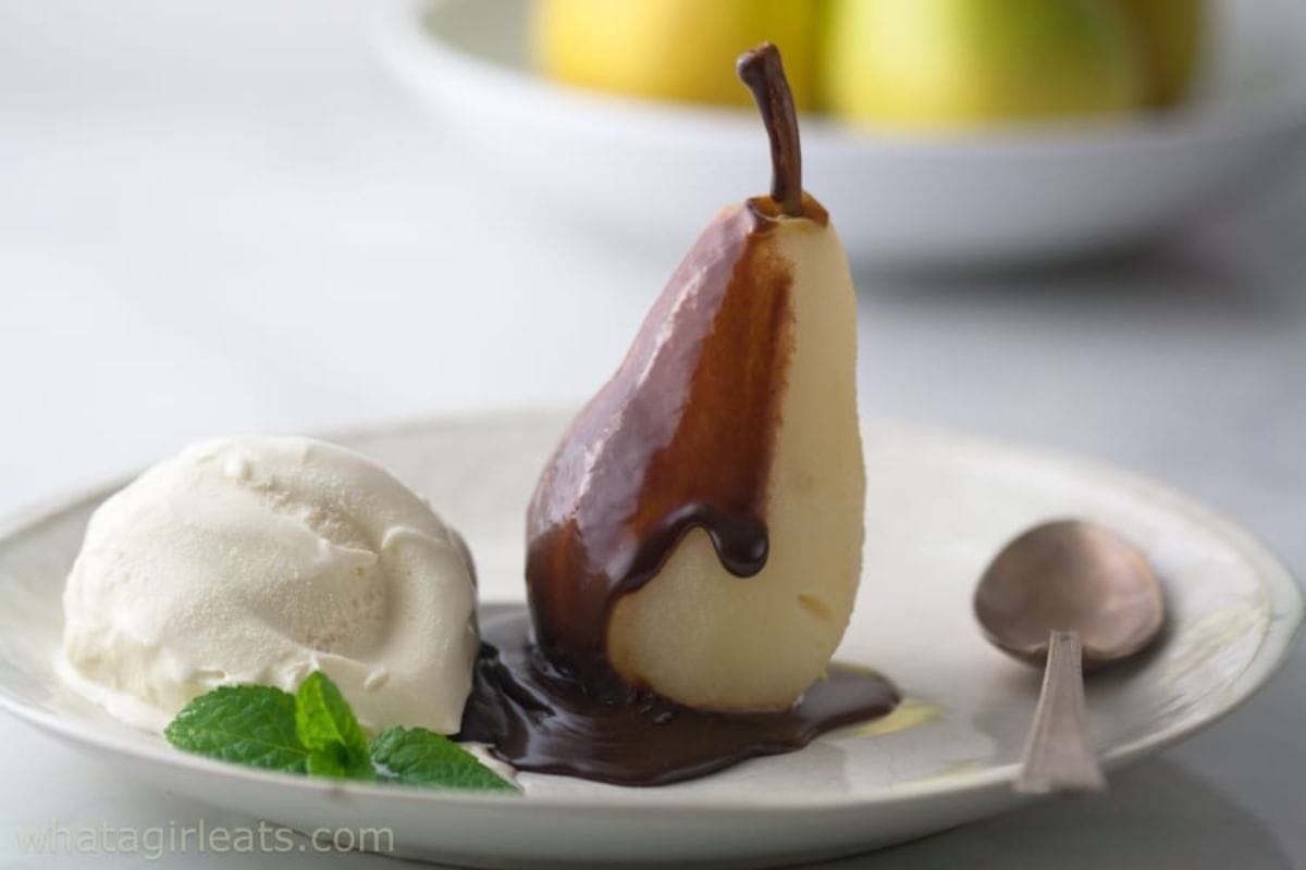 Poached pear covered with chocolate on a plate