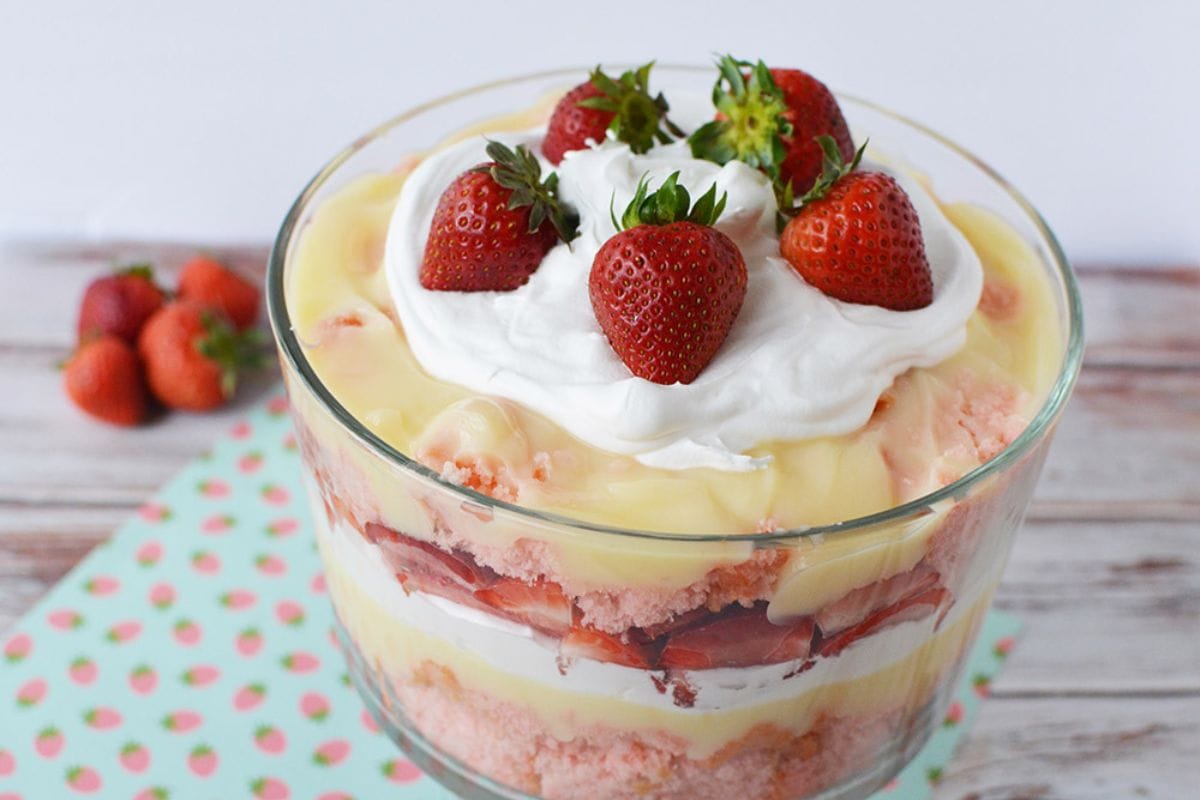 strawberries, cake, whipped cream, and pudding layered in a trifle bowl