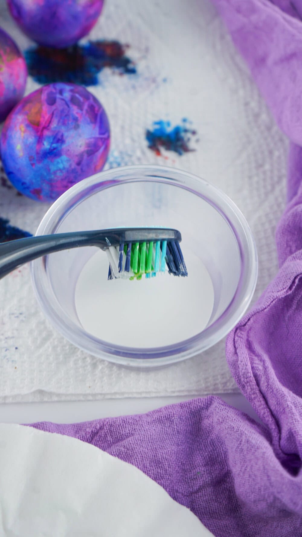 Toothbrush dipping into white paint.