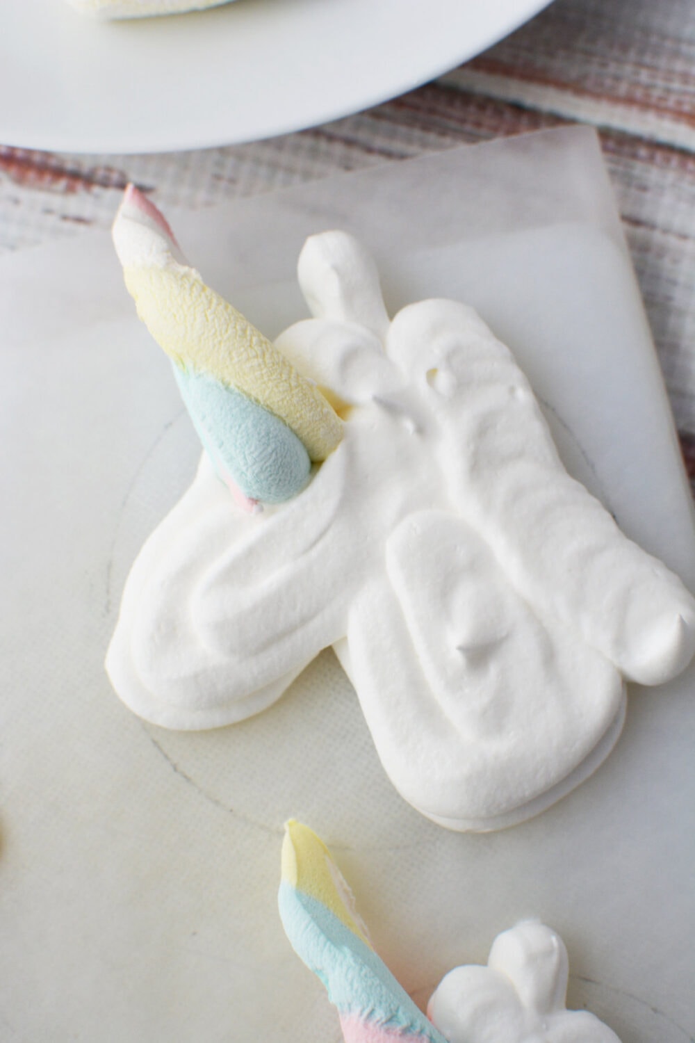 Rainbow marshmallow unicorn horn on whipped cream