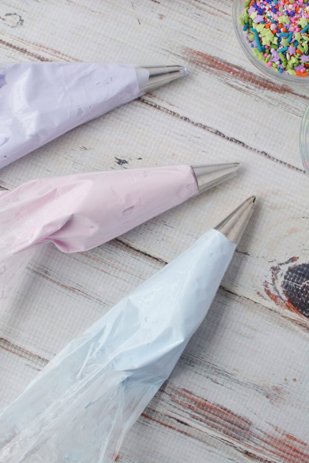 Colored whipped topping in piping bags.