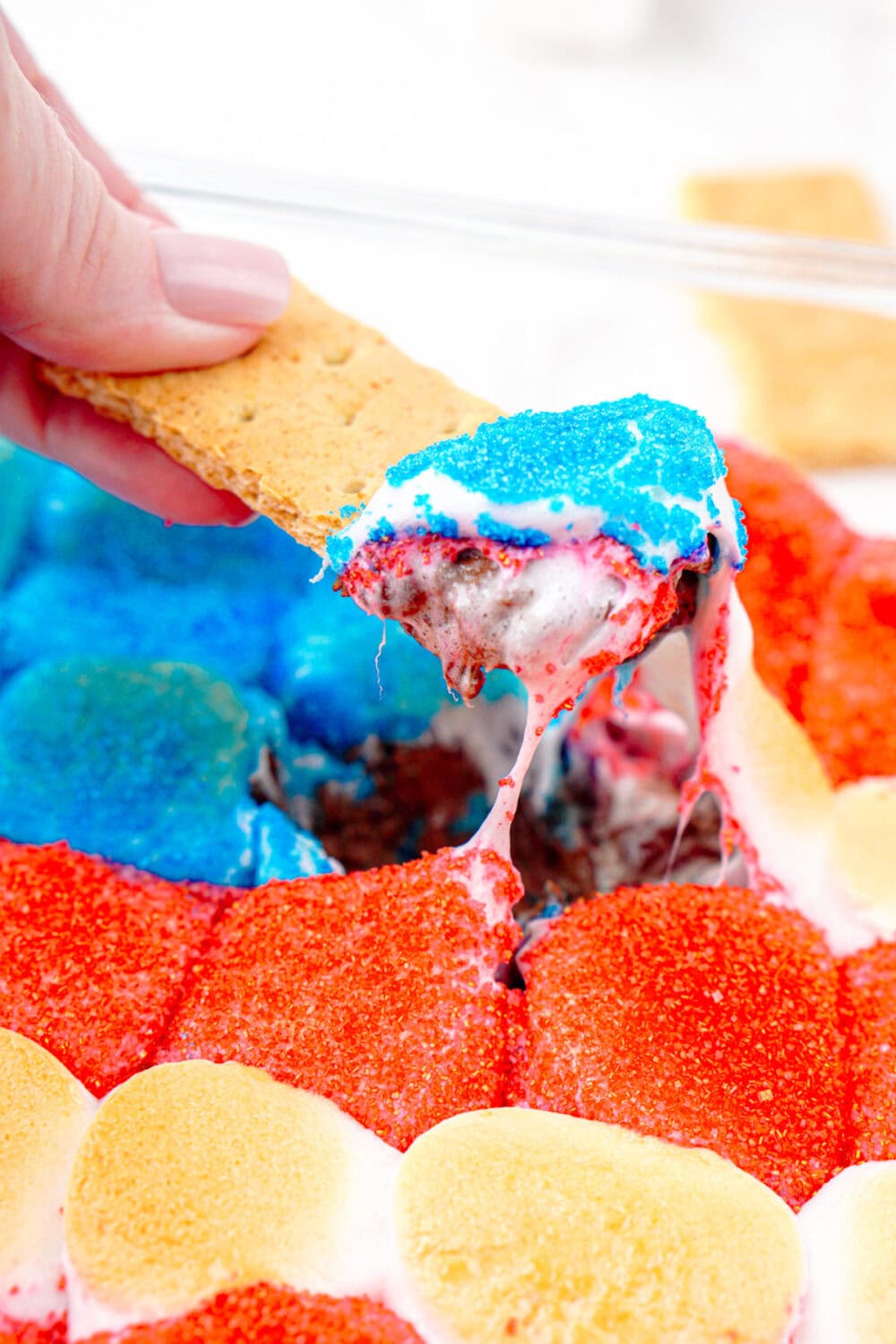 dipping a graham cracker into gooey smores dip