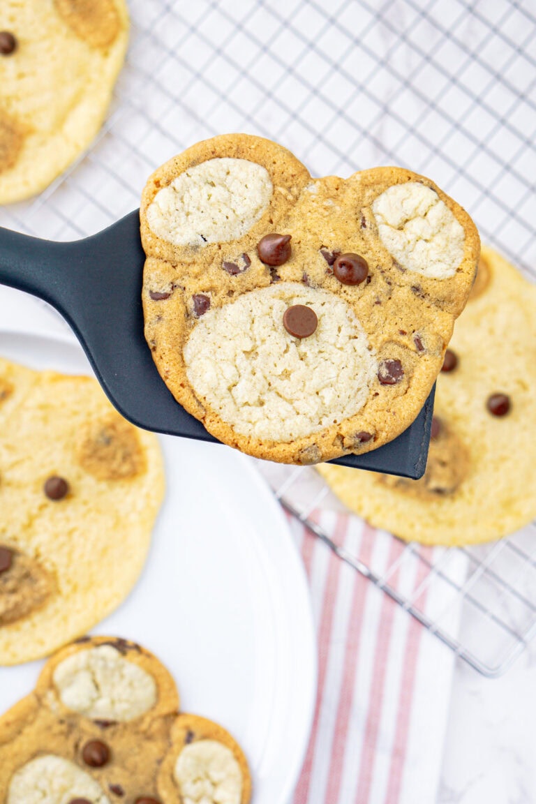 Holding a cookie that looks like a bear on a spatula